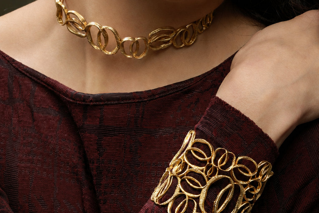 Modella che indossa girocollo, bracciale manchette e orecchino dorati della collezione Identity di Tiziana Piola